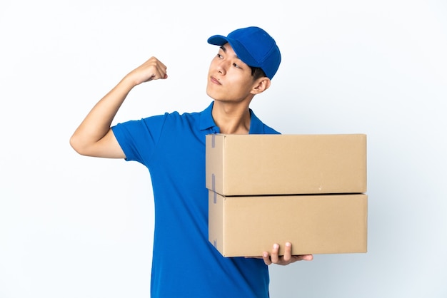 Delivery Chinese man isolated on white wall doing strong gesture