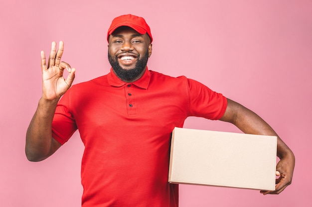 Delivery concept. African american delivery black man carrying parcel. Ok sign.