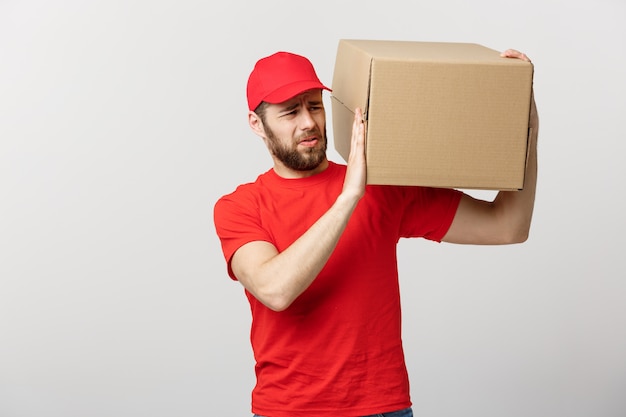 Delivery Concept: handsome Delivery man with boxes, delivery, courier with worry facial expression.