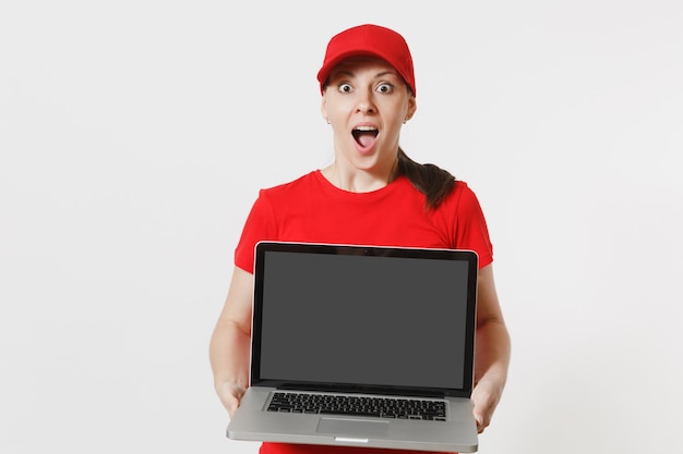 Delivery concept. Woman in red cap, t-shirt isolated on white background. Professional caucasian female working as courier holding pc computer with blank empty screen to copy space for advertisement.