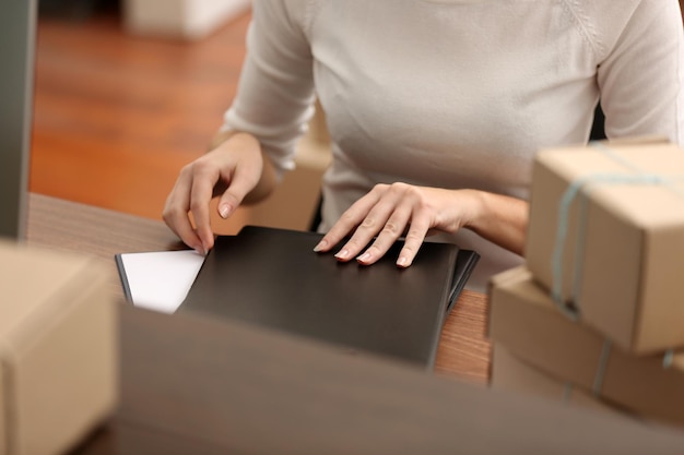 Photo delivery concept woman signs papers among parcels close up