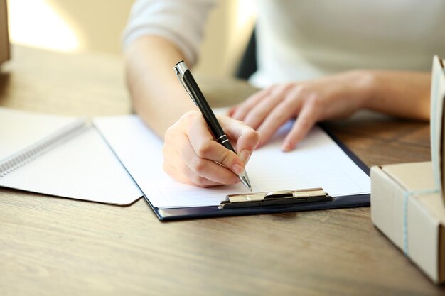 Delivery concept Woman signs papers among parcels close up