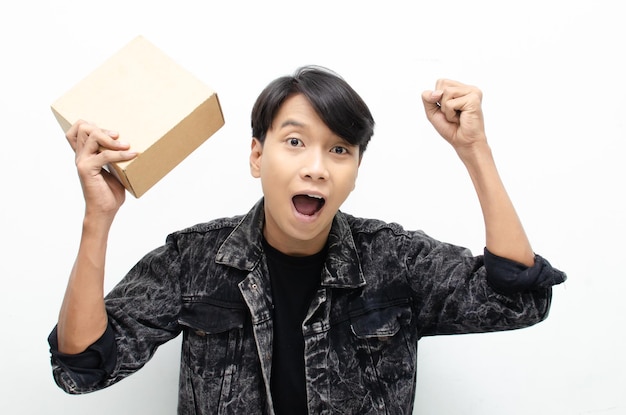 Концепция курьерской доставки и службы доставки. Молодой азиатский мужчина держит пакет в картонной коробке