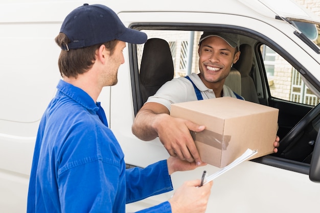 Delivery driver handing parcel to customer in his van