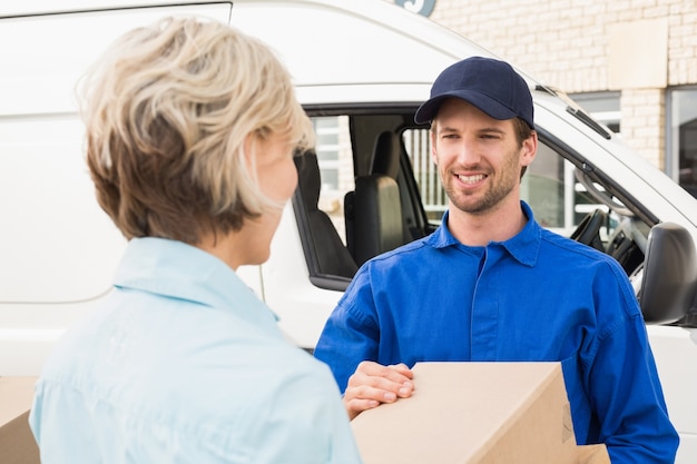 Foto driver di consegna che passa pacchi a cliente felice