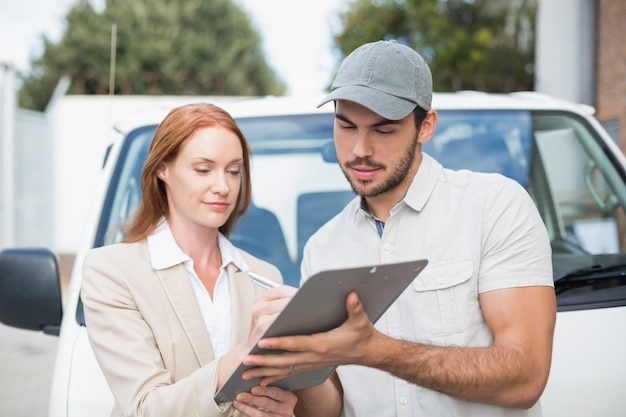 Delivery driver showing where to sign to customer