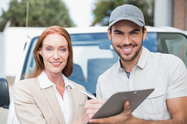 Delivery driver showing where to sign to customer