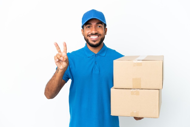 Delivery Ecuadorian man isolated on white background smiling and showing victory sign