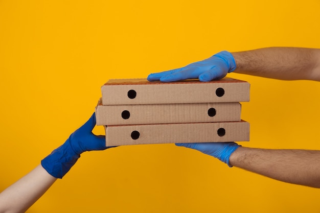 Delivery food in pandemic. man giving pizza boxes to woman