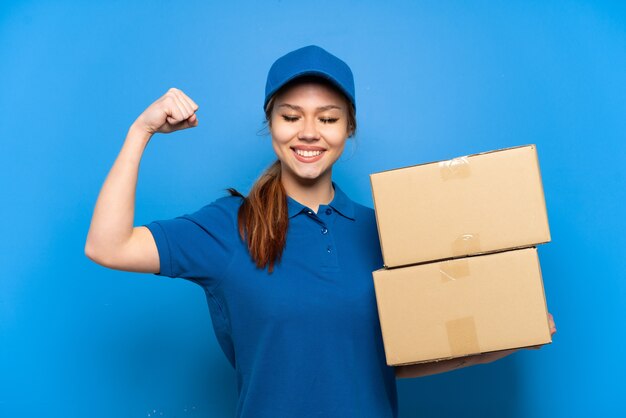 Delivery girl over isolated blue wall doing strong gesture