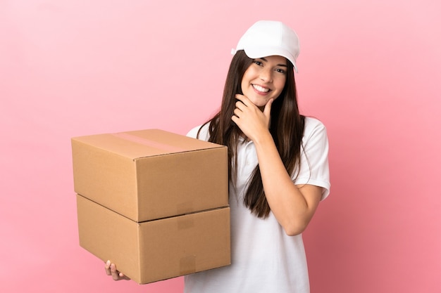 Delivery girl isolated pink wall happy and smiling