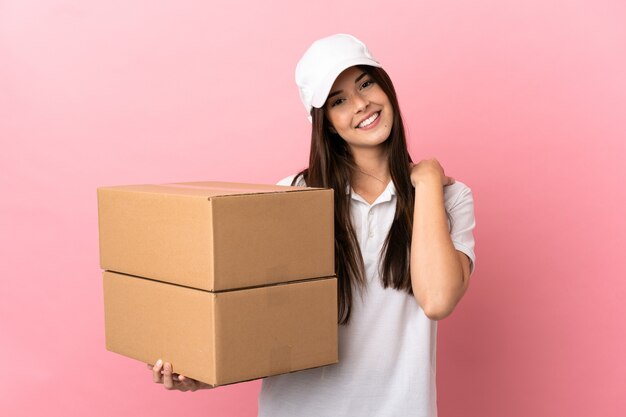 Delivery girl over isolated pink wall laughing