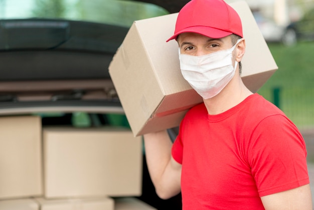 Photo delivery guy wearing mask holding box