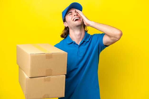 Delivery handsome man isolated on yellow background smiling a lot