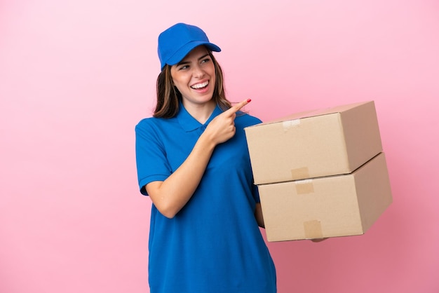 Delivery Italian woman isolated on pink background pointing finger to the side and presenting a product