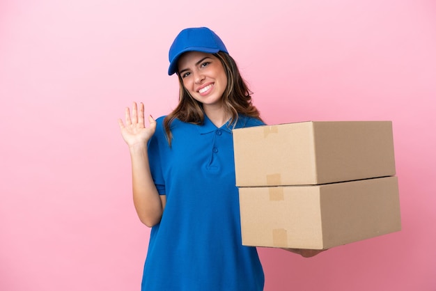 Photo delivery italian woman isolated on pink background saluting with hand with happy expression