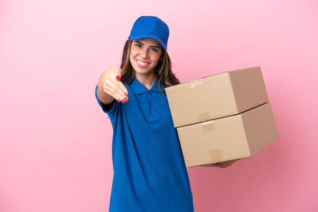 Delivery Italian woman isolated on pink background shaking hands for closing a good deal