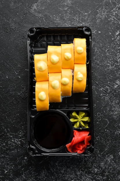 配達日本食寿司ロールとチーズわさびと醤油をプラスチックの箱に入れて上面図