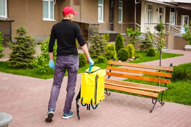 delivery, mail and people concept - happy man delivering food in disposable paper bag to customer home