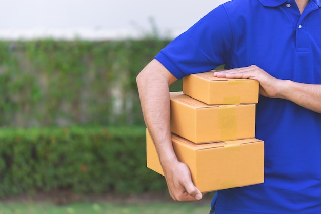 Delivery man in blue is handing packages