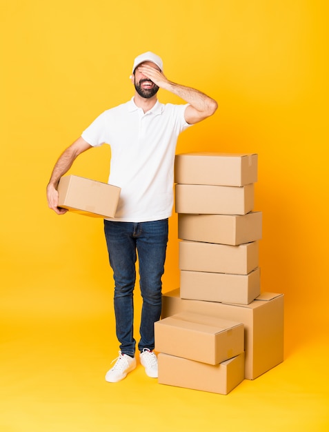 delivery man among boxes covering eyes by hands