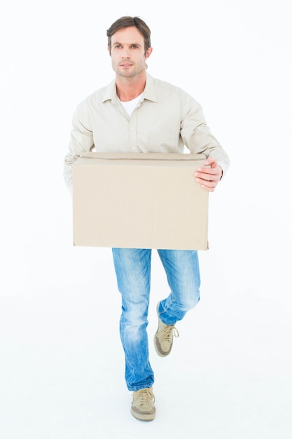 Delivery man carrying cardboard box while walking