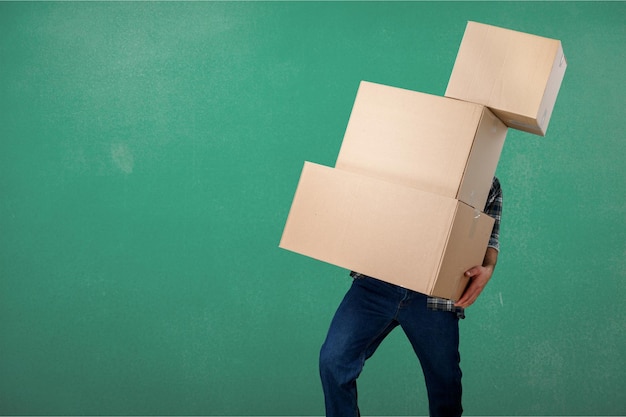 Delivery man carrying stacked boxes