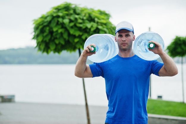 Delivery man carrying water bottle on shoulder.