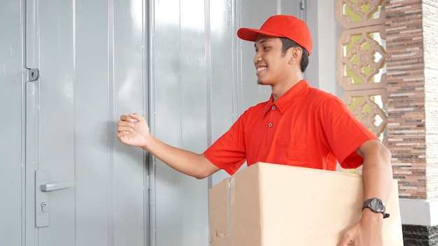 Delivery man delivers the box in front of the customer's house