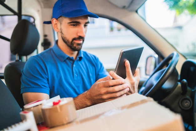 Delivery man driver using digital tablet.