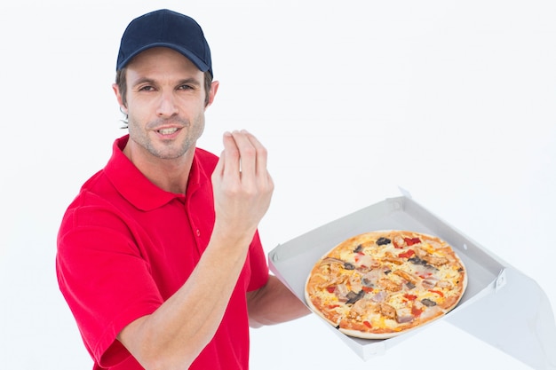 Delivery man gesturing while holding fresh pizza