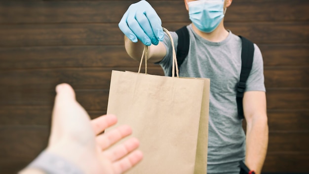 The delivery man gives the bag to the woman