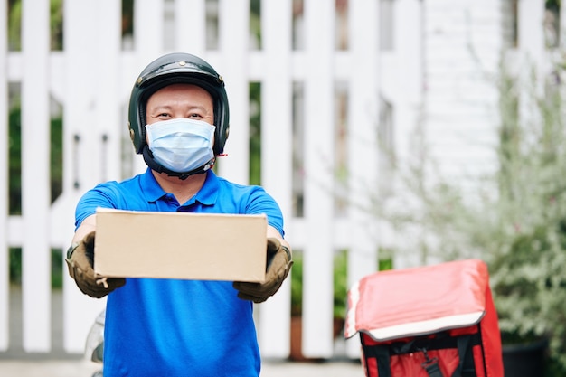 Delivery man giving cardboard box