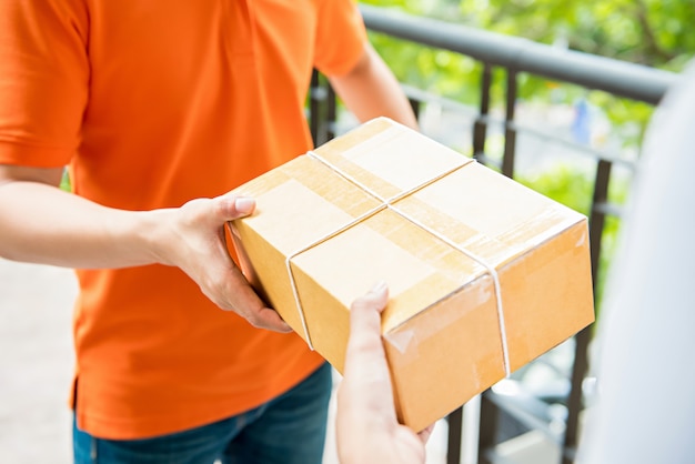 Photo delivery man handing a parcel box over to a customer