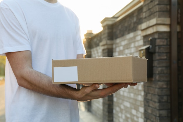 Delivery man hold blank box outdoor, space for text
