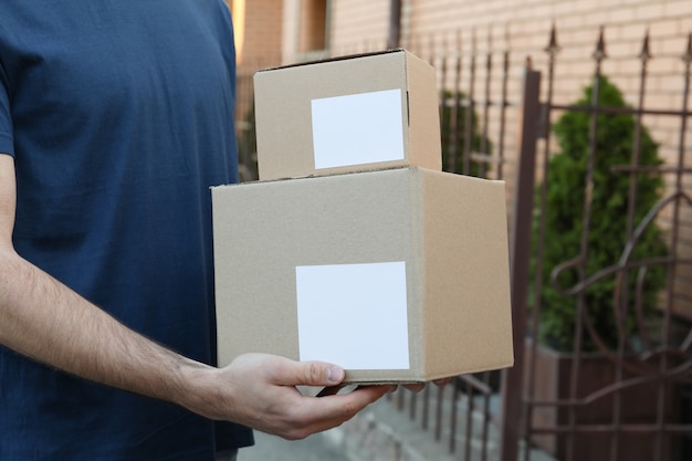 Delivery man hold blank boxes outdoor