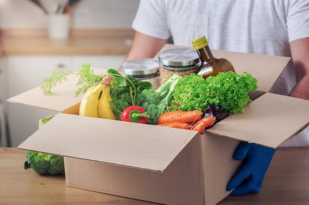 Delivery man holding cardboard boxes with food