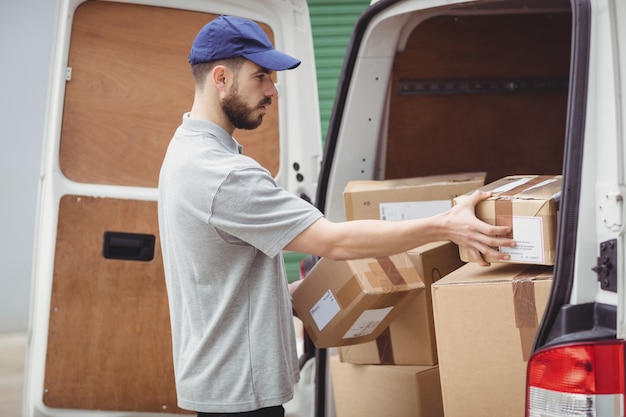 Delivery man holding packages to load his van