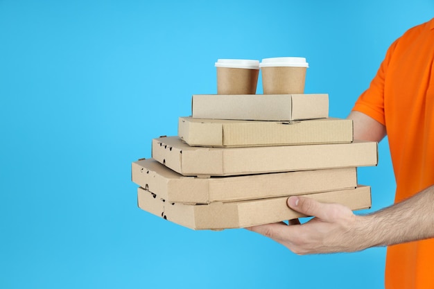 Delivery man holds food on blue background