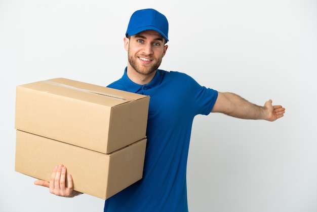 Delivery man over isolated white background extending hands to the side for inviting to come