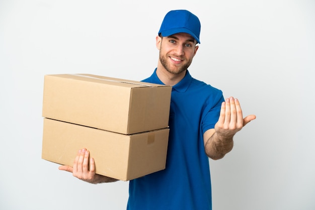 Delivery man over isolated white background inviting to come with hand. Happy that you came