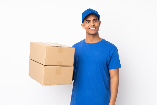 Delivery man over isolated white wall smiling a lot