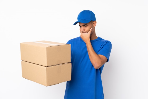 Delivery man over isolated white wall with sad expression