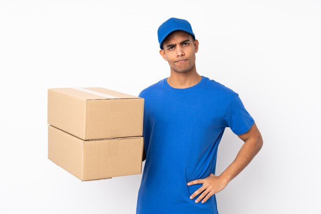 Delivery man over isolated white wall with sad expression