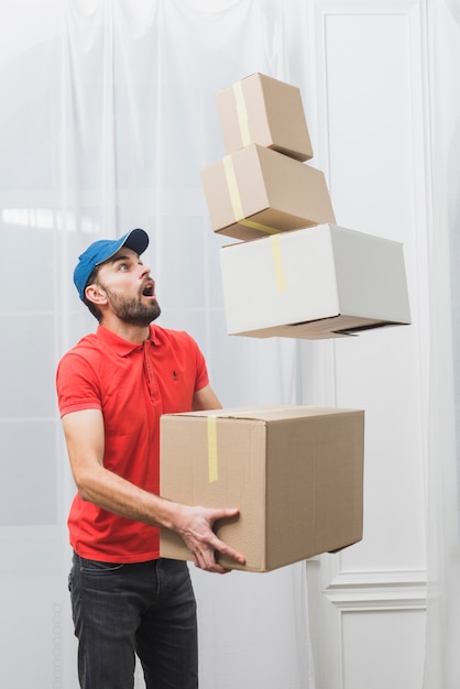 Photo delivery man looking at falling boxes