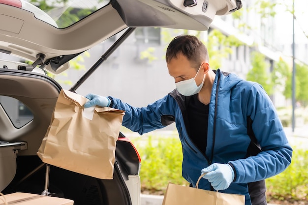 Premium Photo  Delivery man in a medical mask and gloves delivers