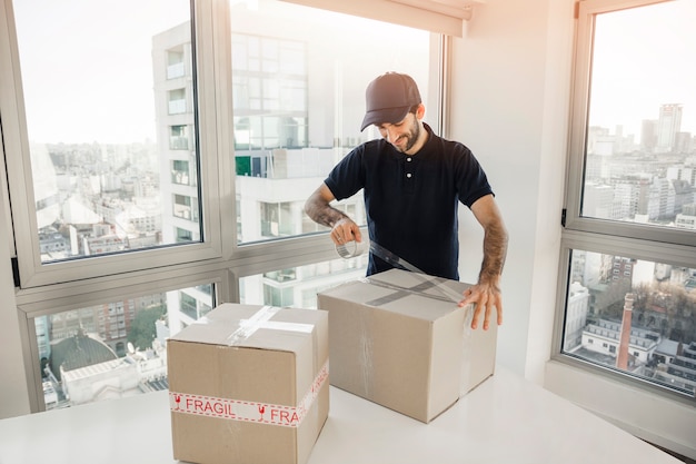 Delivery man packing cardboard box