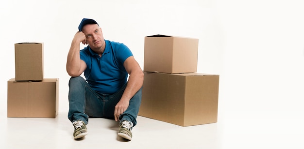 Delivery man posing with cardboard boxes