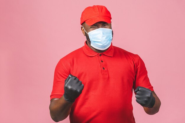 Delivery man in red cap blank t-shirt uniform sterile face mask gloves. Guy employee working courier