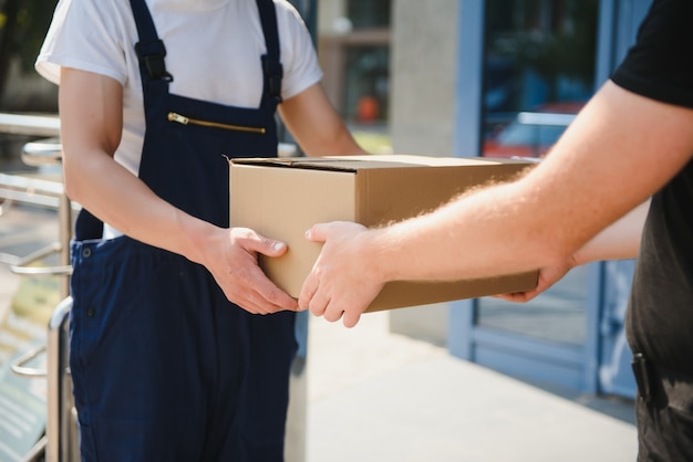 Фото Служба доставки с коробками в руках, стоящая перед дверями дома клиента